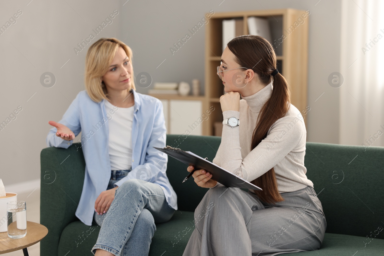 Photo of Psychotherapist working with patient on sofa in office