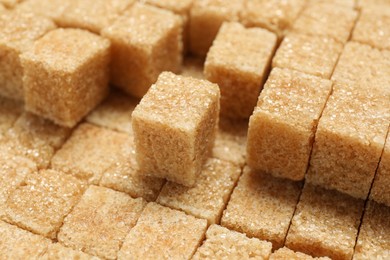 Brown sugar cubes as background, closeup view
