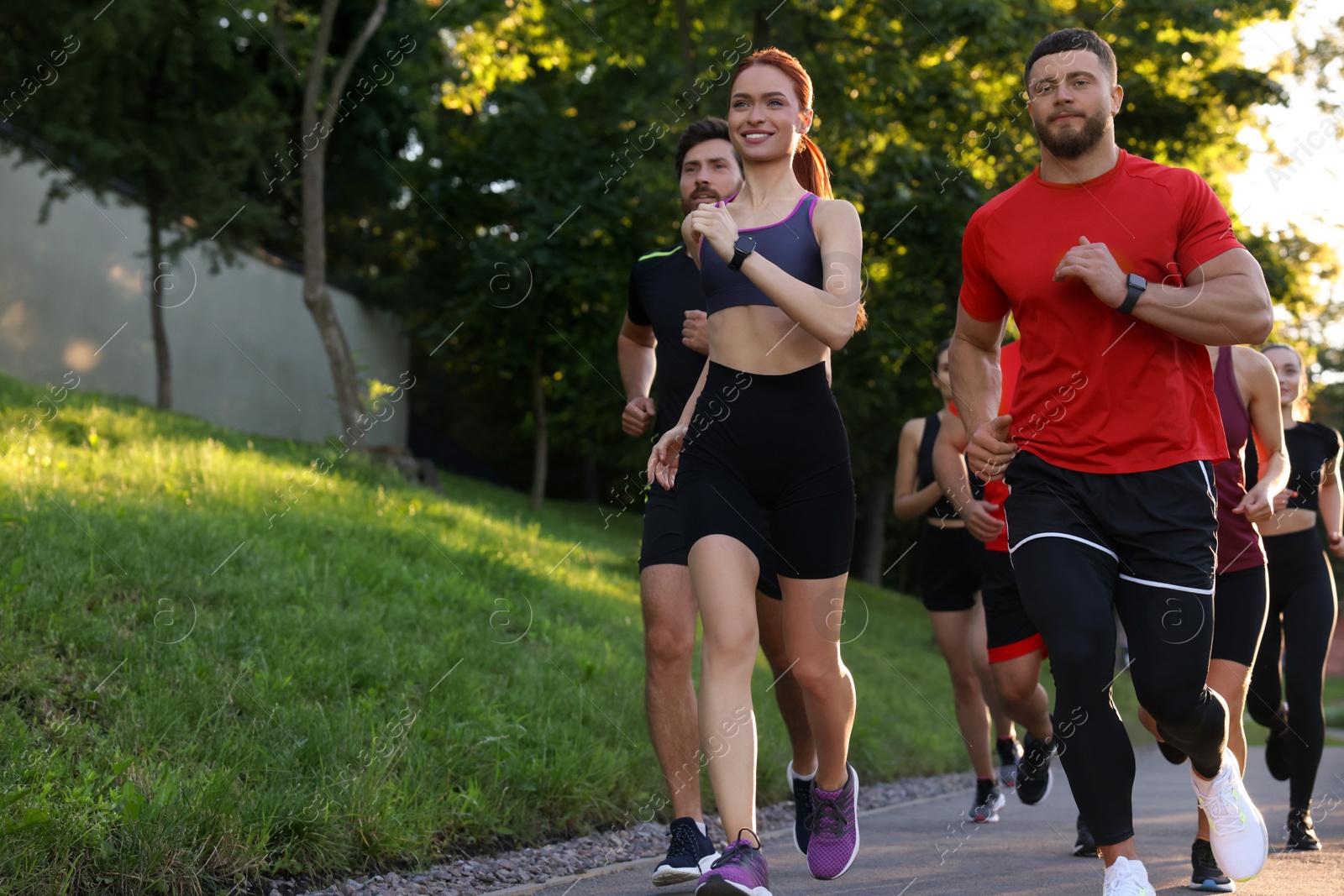 Photo of Group of people running outdoors. Space for text