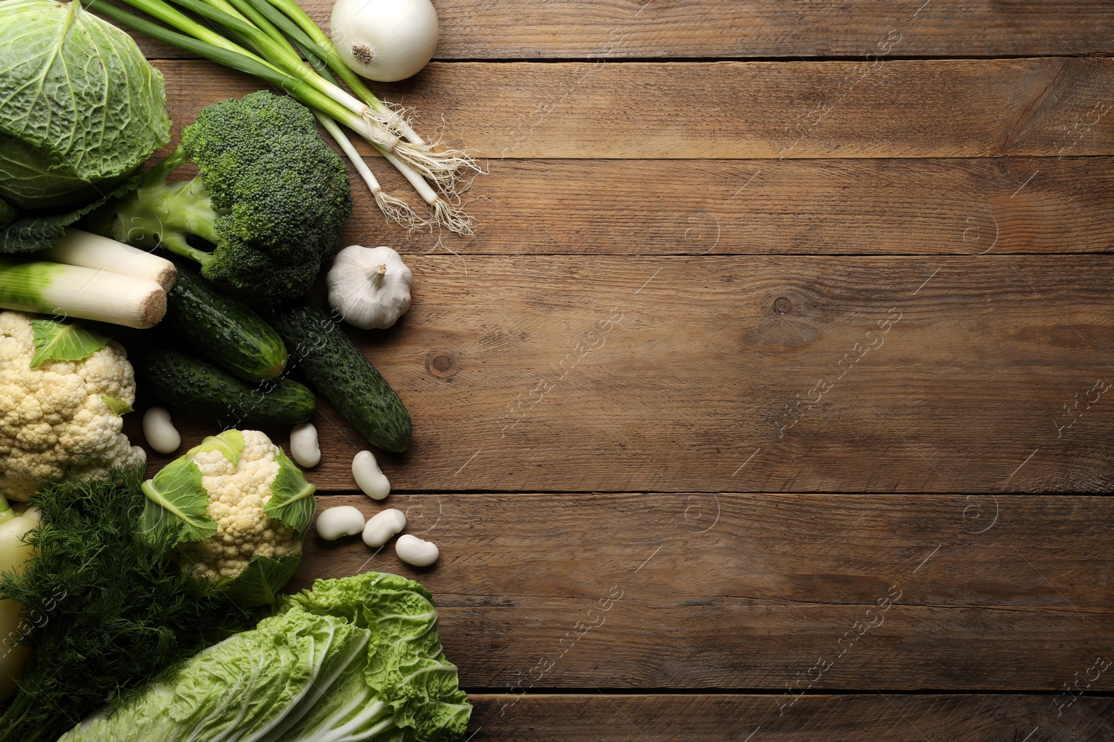 Photo of Different fresh ripe vegetables on wooden table, flat lay. Space for text