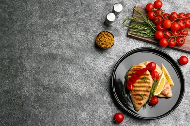 Photo of Flat lay composition with tasty grilled chicken fillets on grey table. Space for text