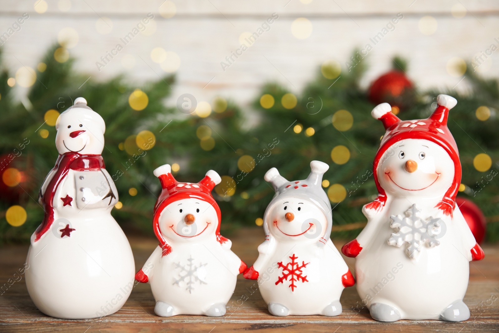 Photo of Funny little snowmen on wooden table. Christmas decor