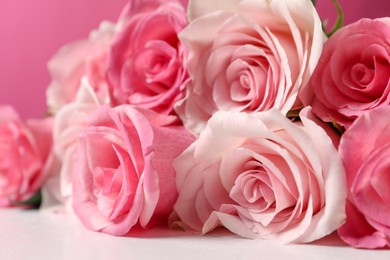 Photo of Bouquet of beautiful roses on light table, closeup