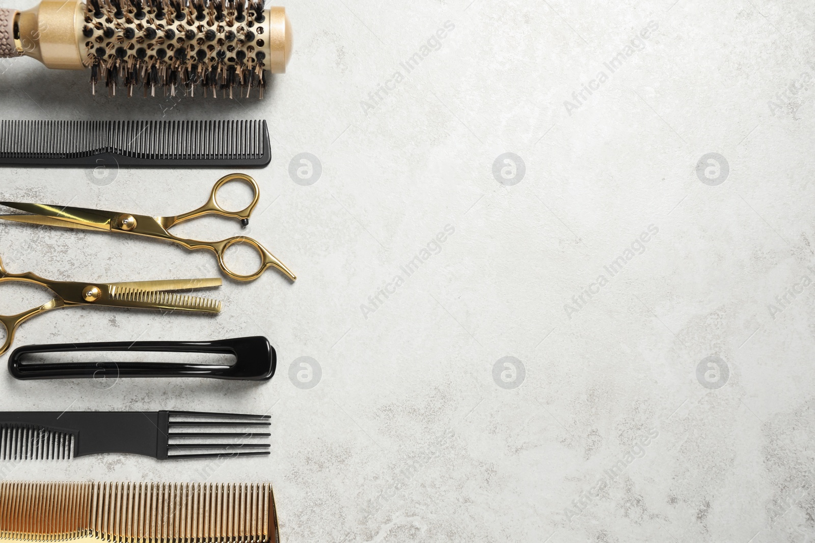 Photo of Professional hair dresser tools on grey textured background, flat lay. Space for text