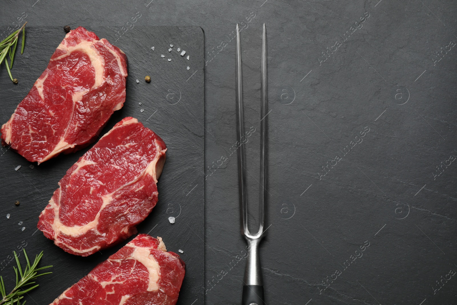 Photo of Flat lay composition with fresh meat steaks on dark table. Space for text