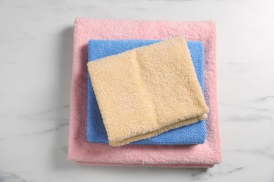 Clean folded towels on white marble table, top view