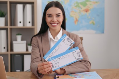 Photo of Travel agent with tickets at table in office