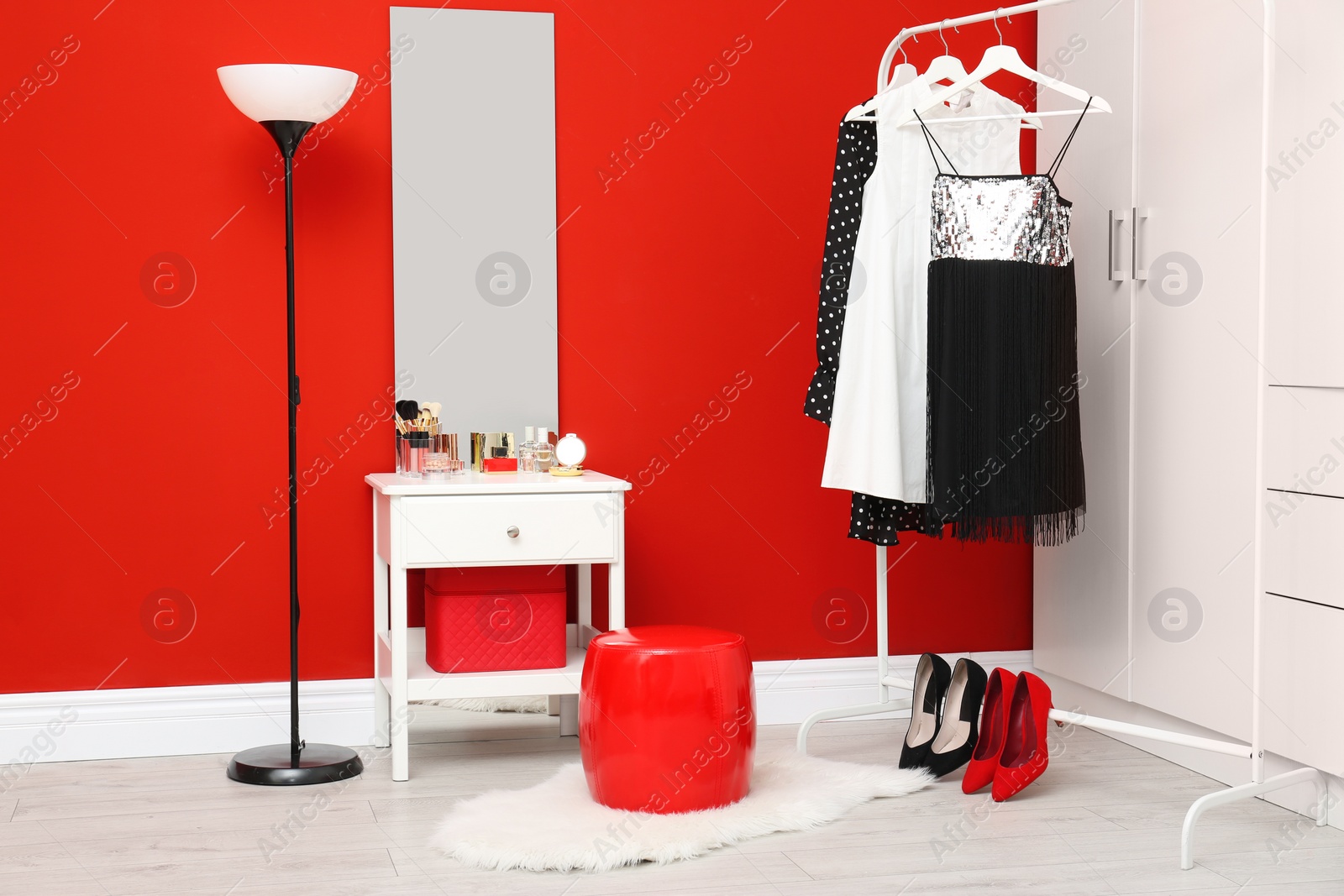 Photo of Stylish room interior with set of makeup products on dressing table