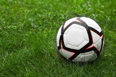 Photo of New soccer ball on fresh green grass outdoors, space for text