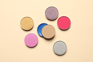 Different beautiful eye shadows on beige background, flat lay