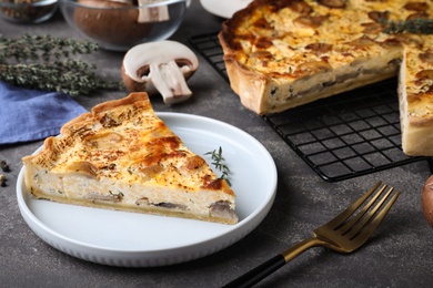 Photo of Delicious pie with mushrooms and cheese served on grey table