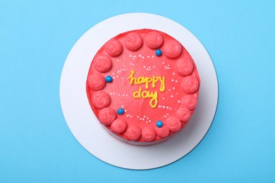 Cute bento cake with tasty cream on light blue background, top view