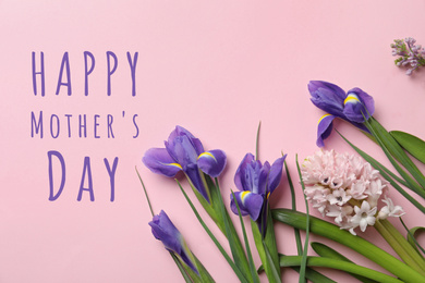 Image of Flat lay composition with beautiful spring flowers and phrase HAPPY MOTHER'S DAY on light pink background