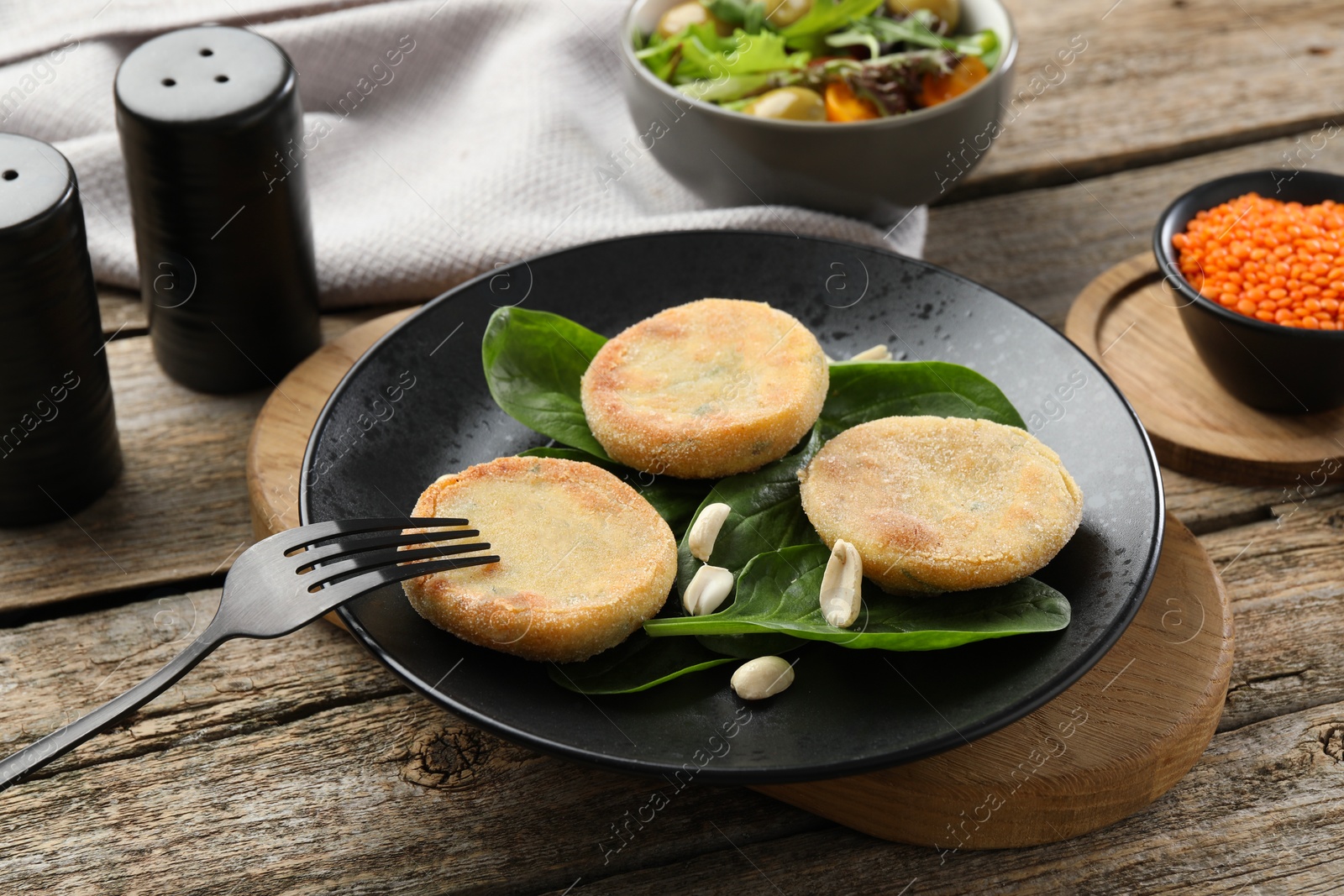 Photo of Plate with healthy dish high in vegetable fats and fork on wooden table, closeup