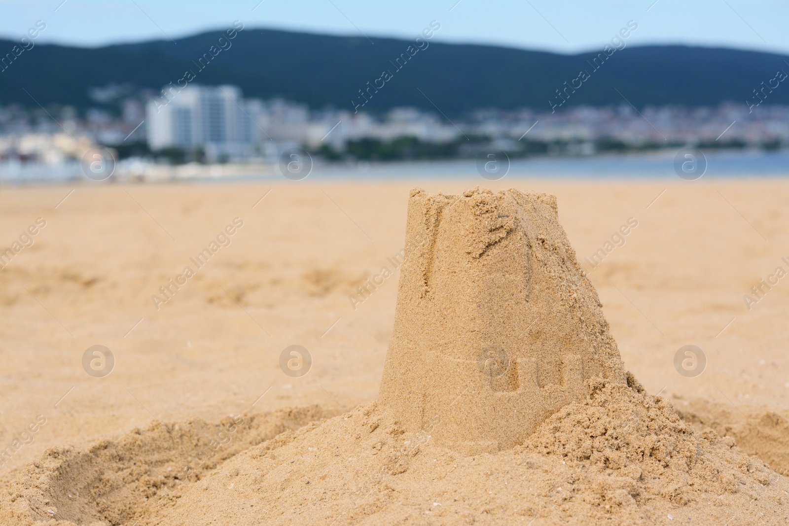 Photo of Beautiful sand castle on beach near sea, space for text