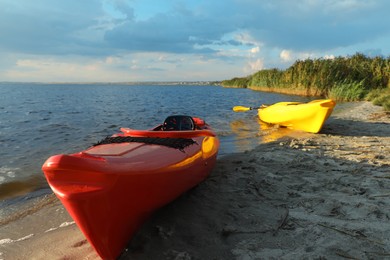 Photo of Beautiful modern kayaks on beach near river