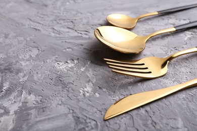 Elegant cutlery set on grey textured table, closeup. Space for text