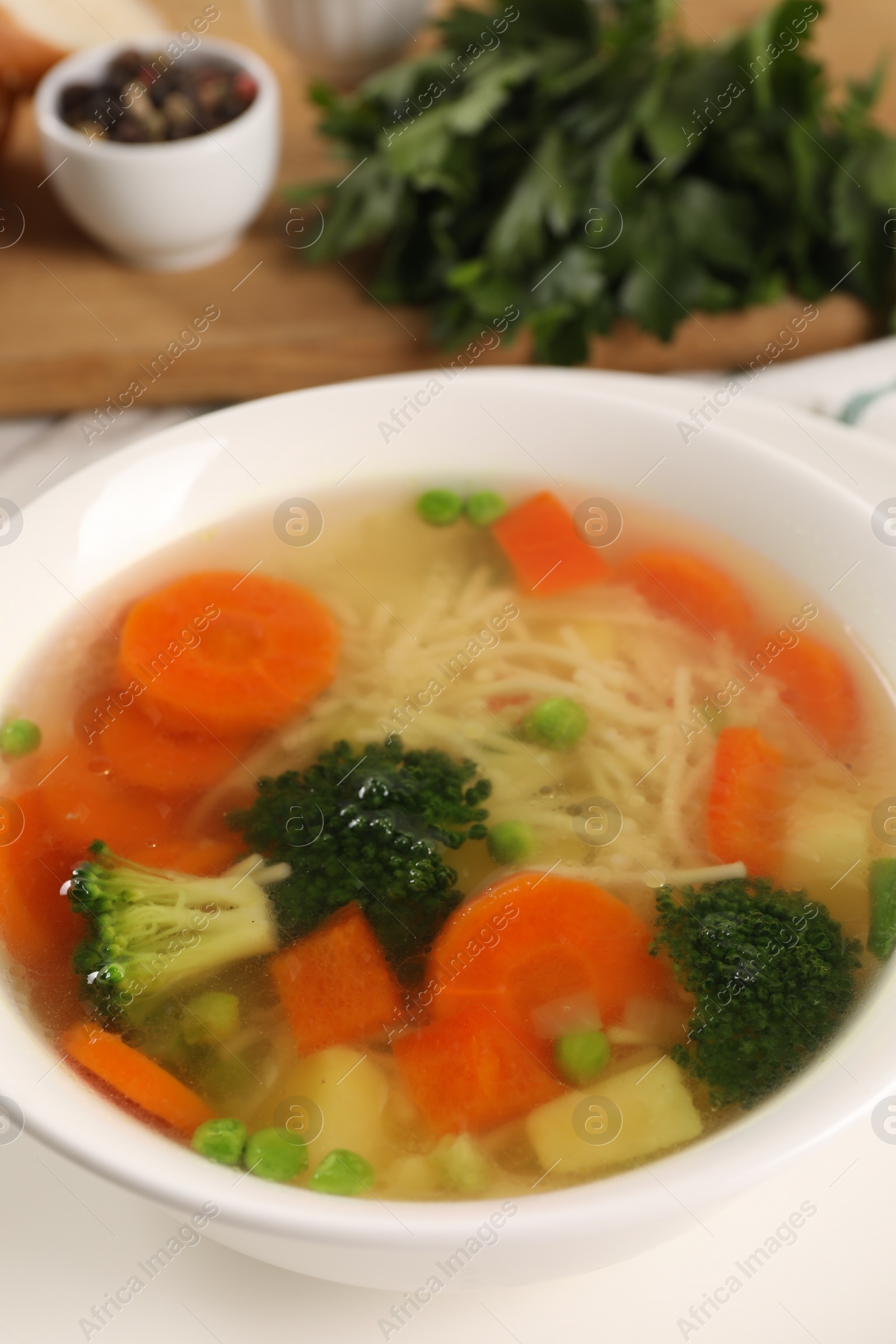 Photo of Delicious vegetable soup with noodles on table, closeup