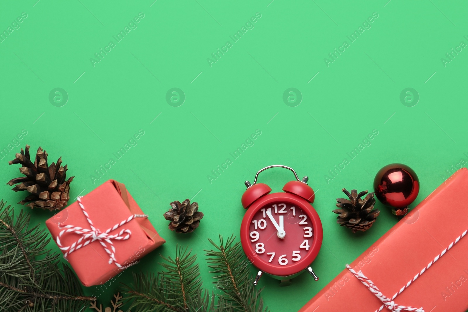 Photo of Flat lay composition with alarm clock and gifts on green background, space for text. Boxing day