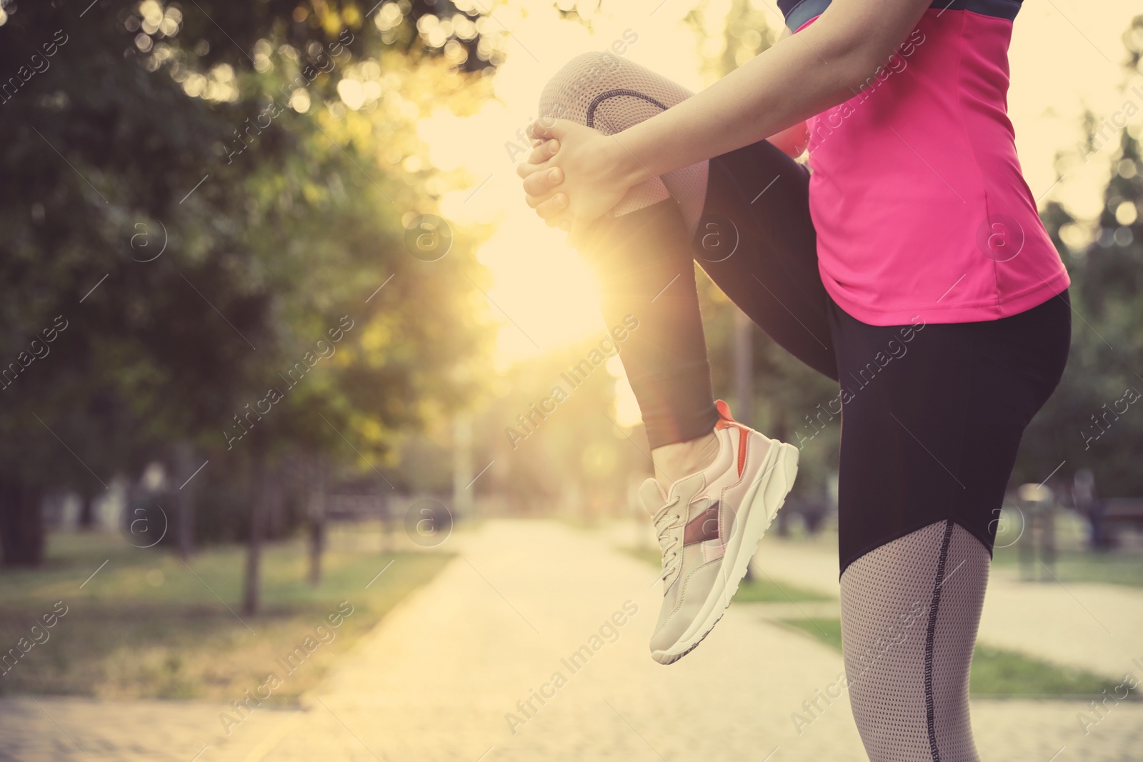 Photo of Woman stretching before morning run in park, closeup. Space for text