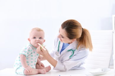 Photo of Children's doctor examining baby's throat in hospital