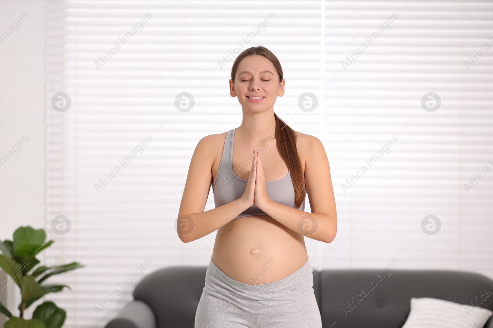 Photo of Pregnant woman meditating at home. Doing yoga
