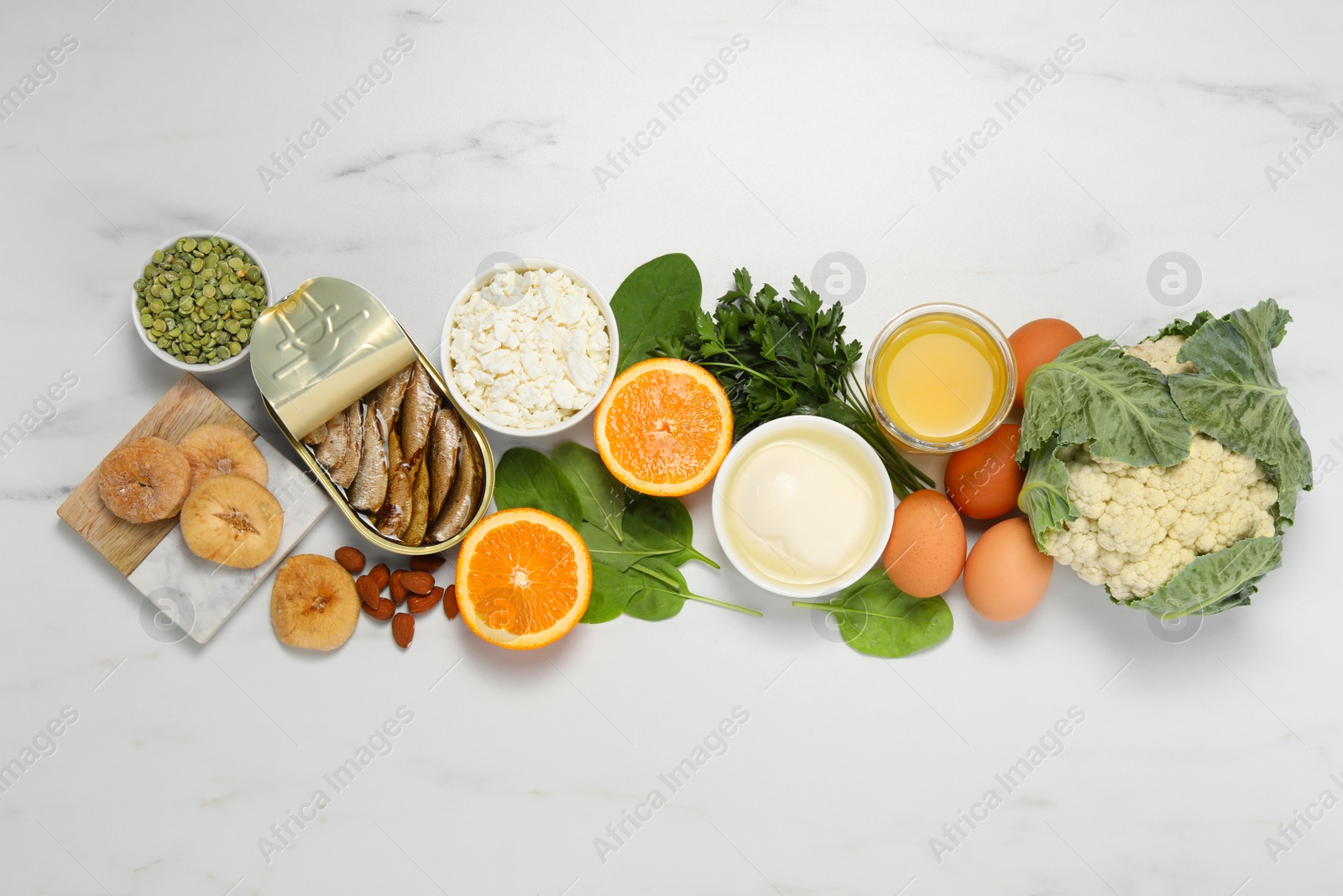 Photo of Set of natural food high in calcium on white marble table, flat lay