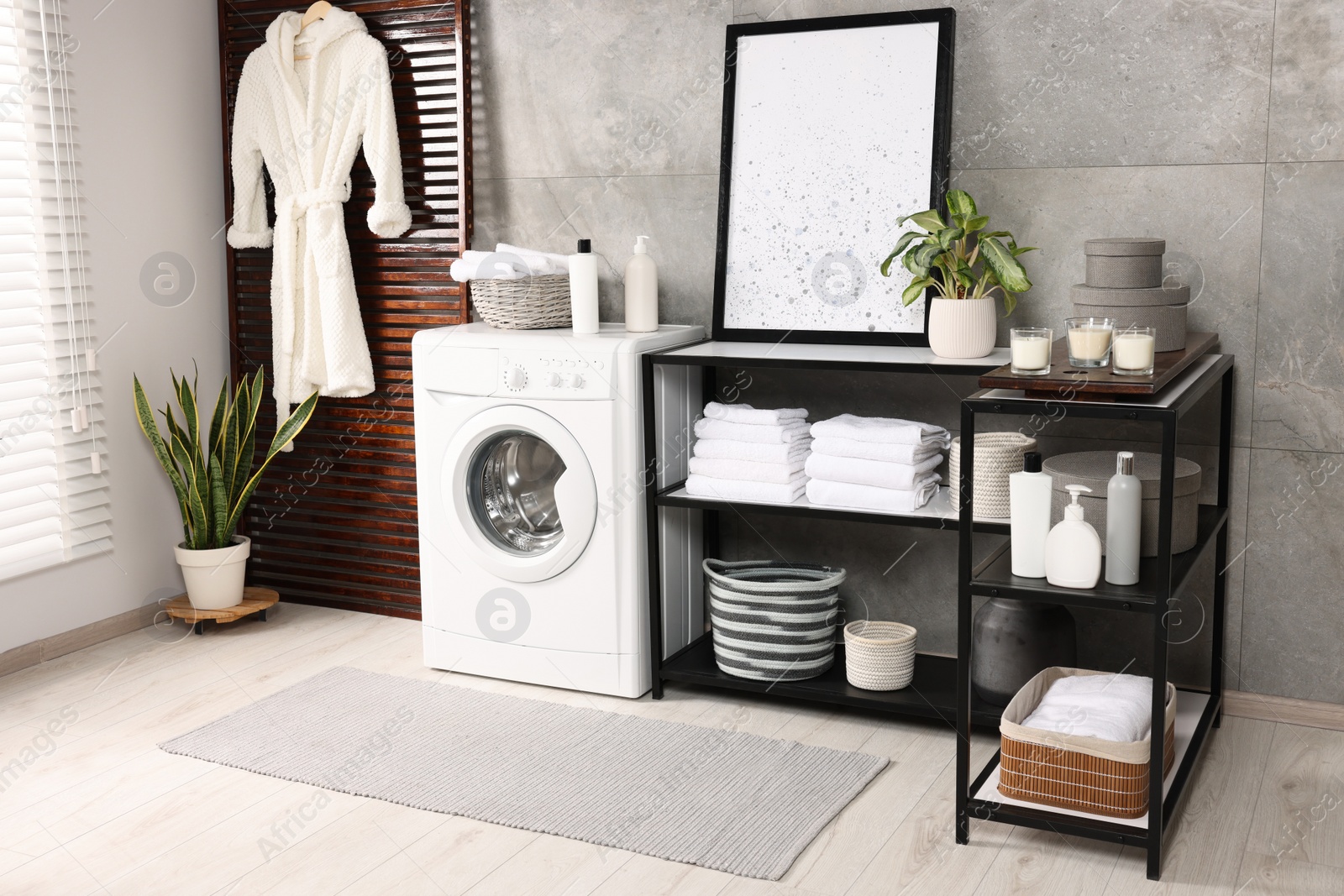 Photo of Stylish laundry room with modern washing machine. Interior design