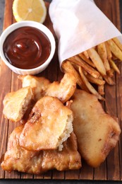 Tasty fish, chips and sauce on table, above view