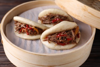 Photo of Delicious gua bao (pork belly buns) on wooden table, closeup
