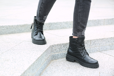 Photo of Woman wearing comfortable stylish boots outdoors, closeup