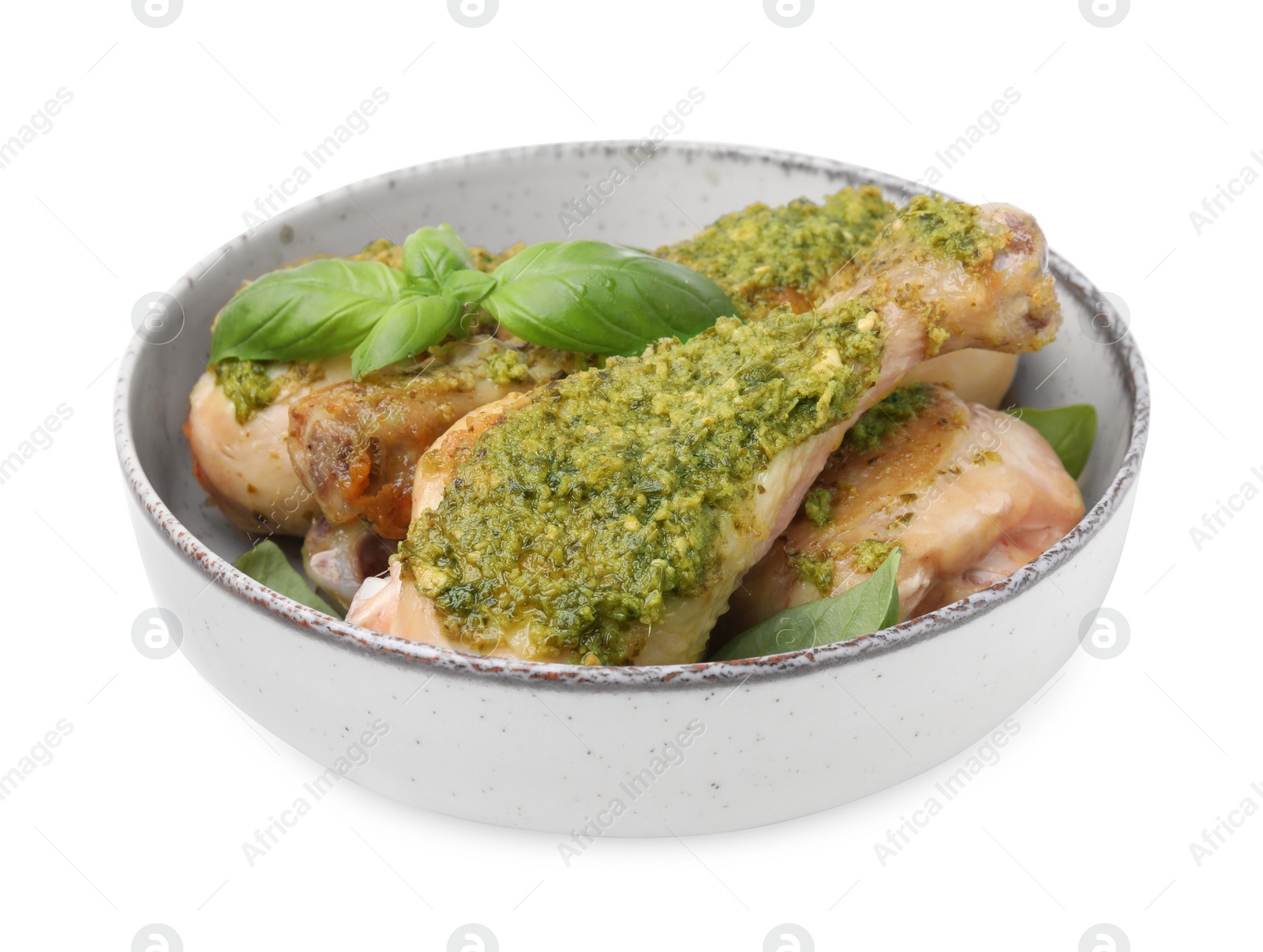 Photo of Delicious fried chicken drumsticks with pesto sauce and basil in bowl isolated on white