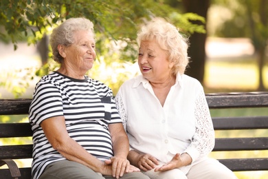 Elderly women resting on bench in park