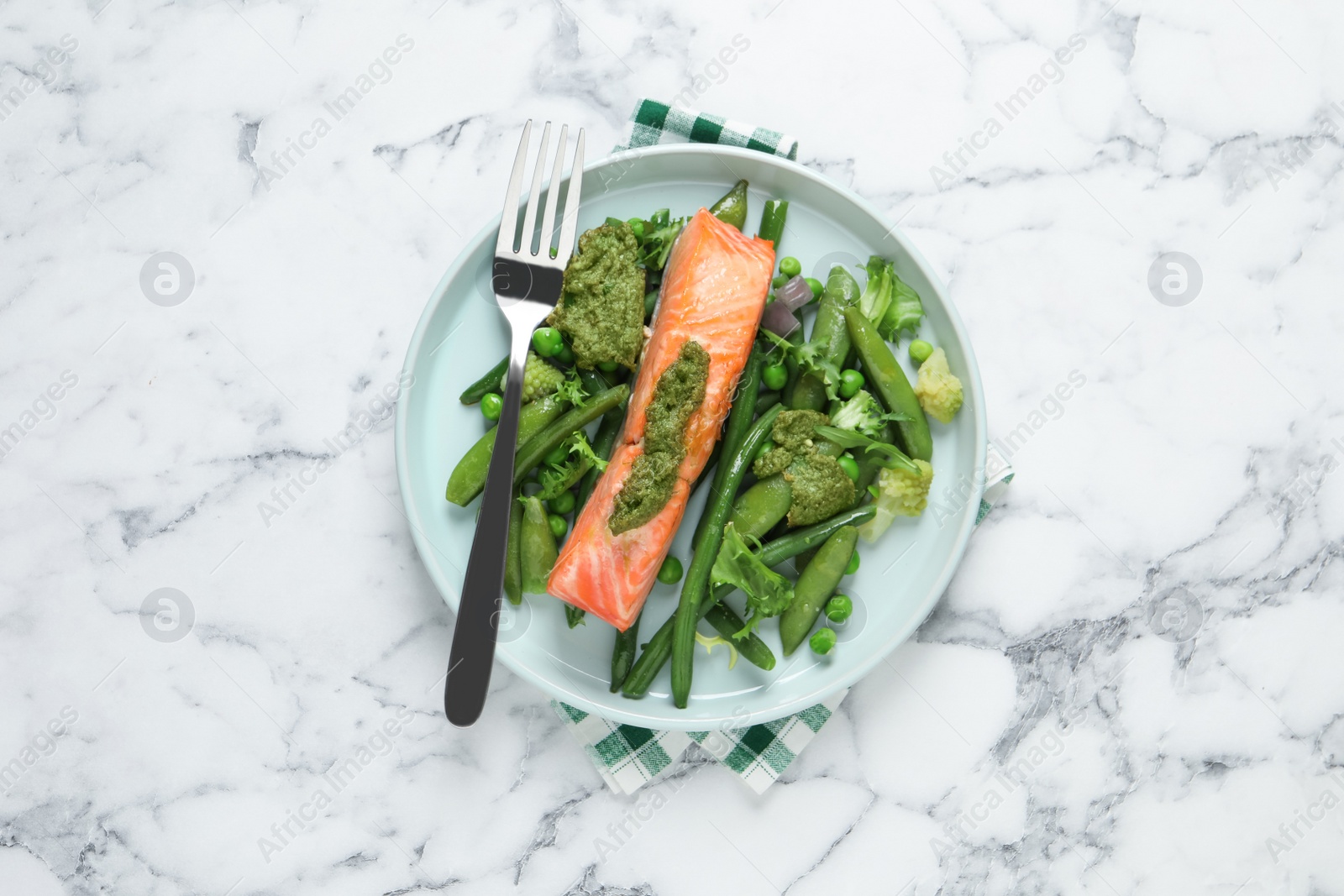 Photo of Tasty cooked salmon with pesto sauce and fresh salad served on white marble table, top view