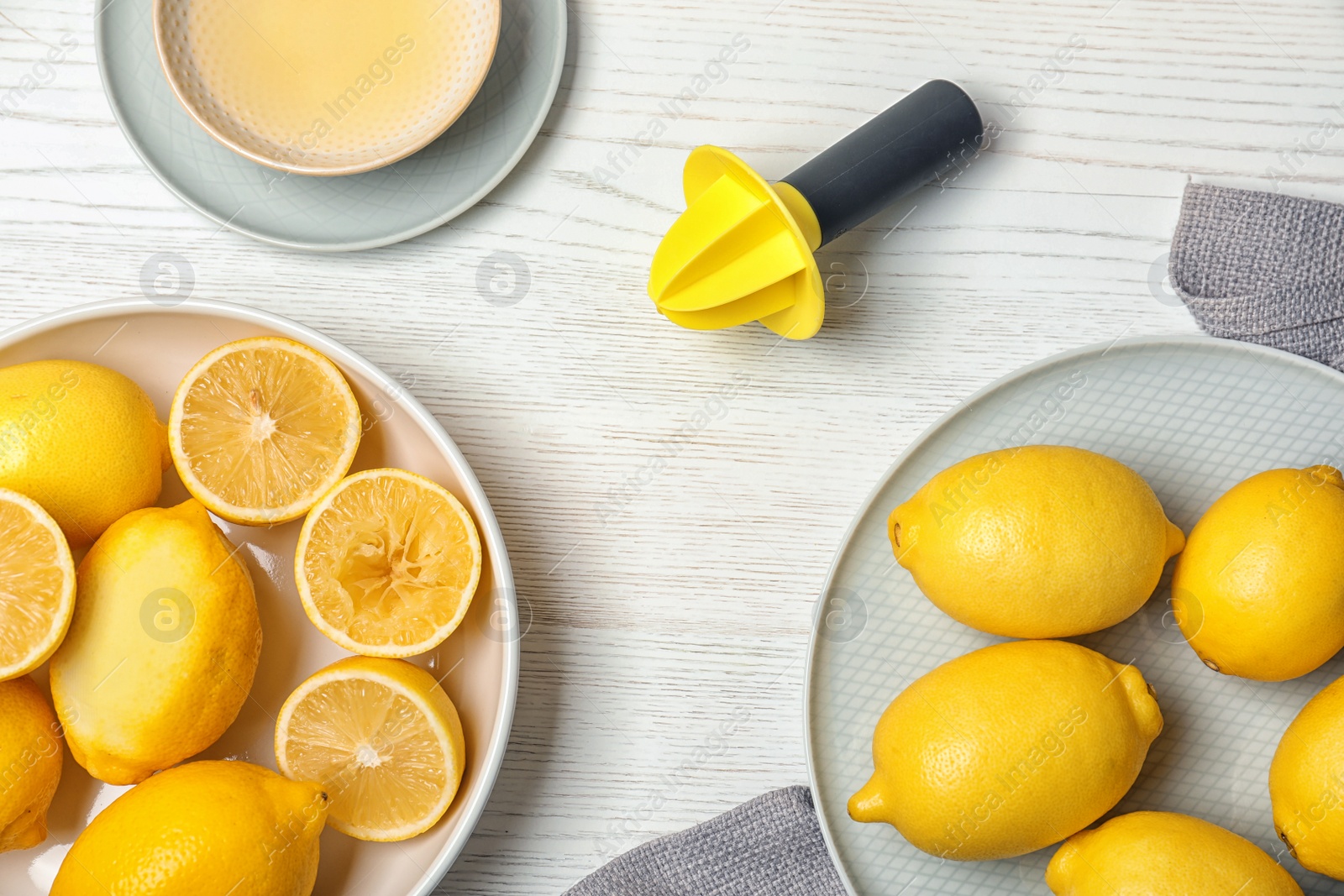 Photo of Flat lay composition with reamer and freshly squeezed lemon juice on table