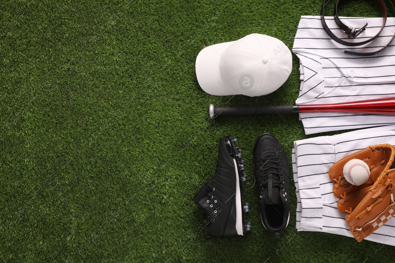 Photo of Flat lay composition with baseball equipment on artificial grass. Space for text