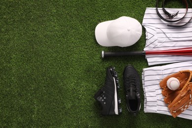 Photo of Flat lay composition with baseball equipment on artificial grass. Space for text