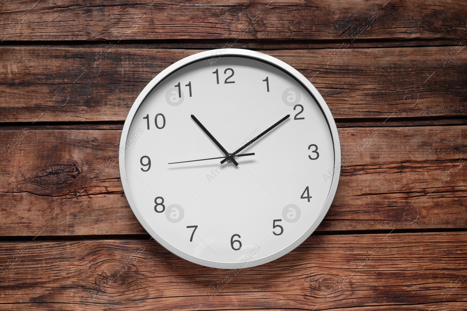 Photo of Stylish round clock on wooden table, top view. Interior element