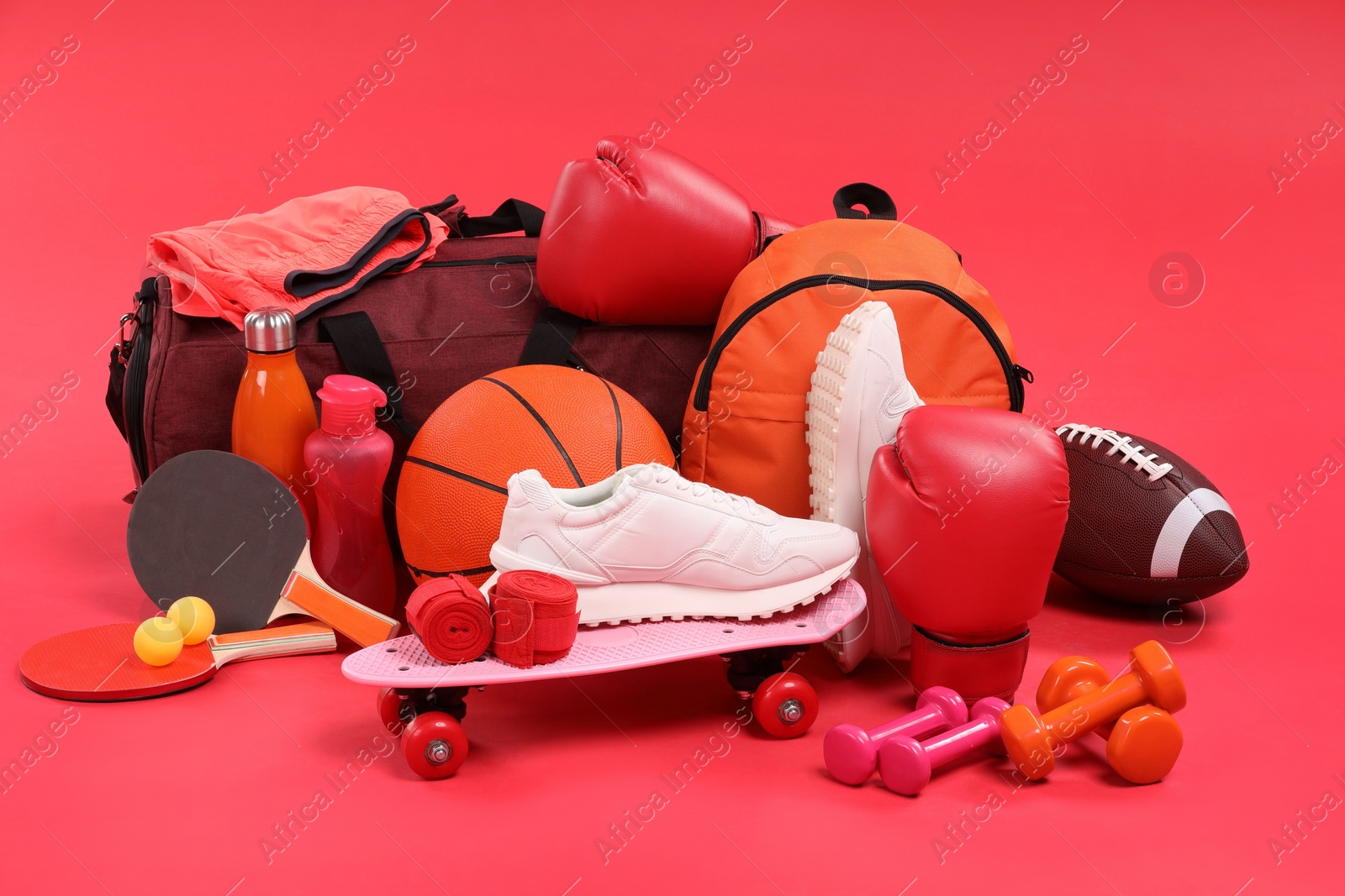 Photo of Many different sports equipment on red background