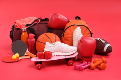 Many different sports equipment on red background