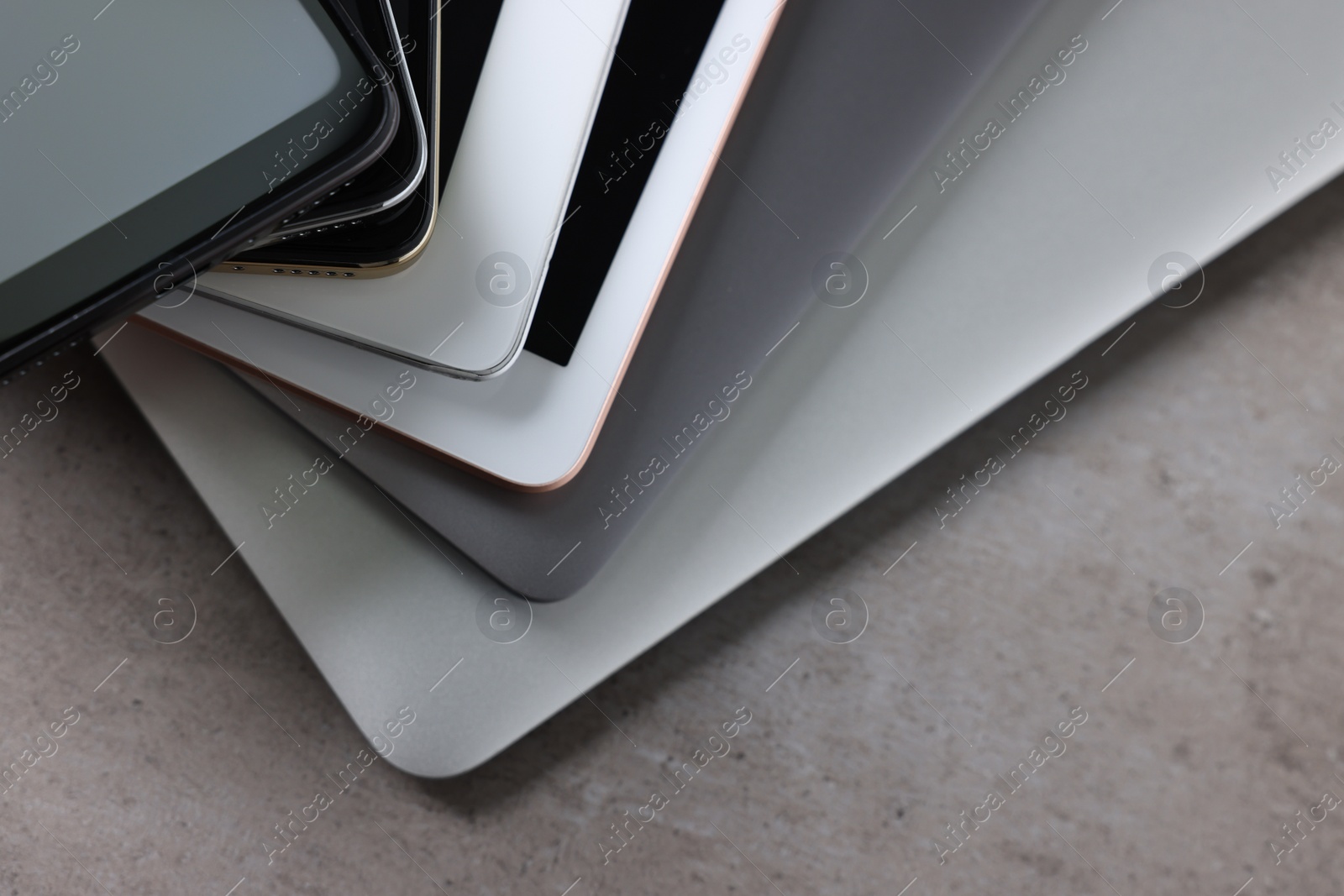 Photo of Many different modern gadgets on grey table, closeup