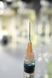Photo of Syringe with medicine against blurred background, closeup