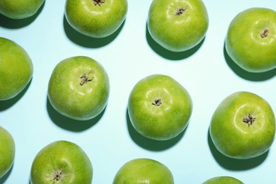 Photo of Ripe green apples on light blue background, flat lay