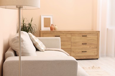 Stylish sofa and chest of drawers in living room. Interior design