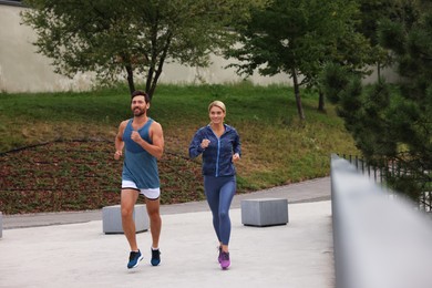 Photo of Healthy lifestyle. Happy sporty couple running outdoors