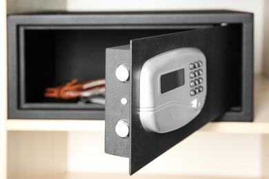 Photo of Open steel safe with wallet, focus on door