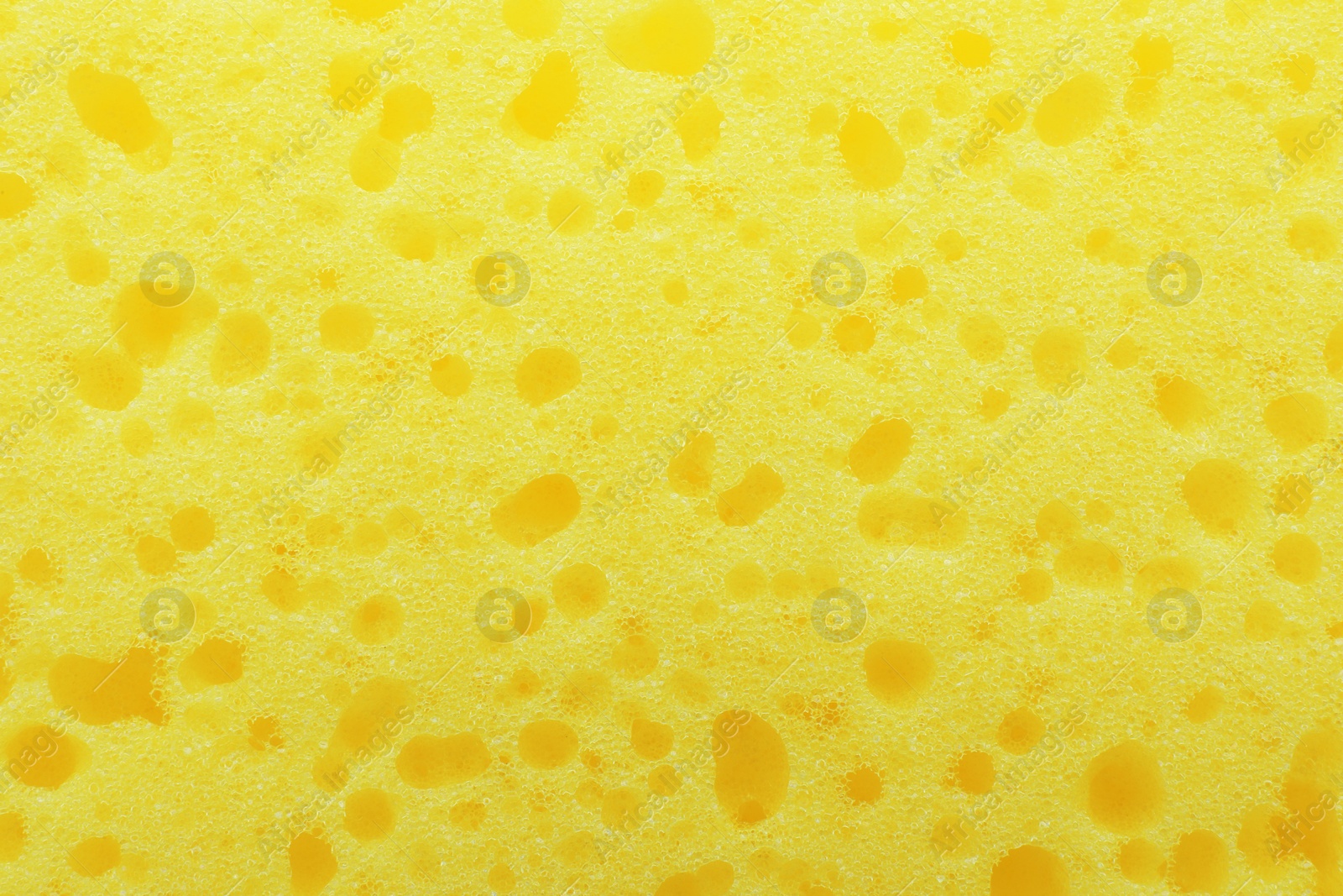 Photo of New yellow sponge as background, closeup view