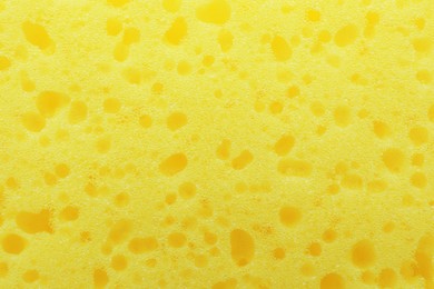 Photo of New yellow sponge as background, closeup view