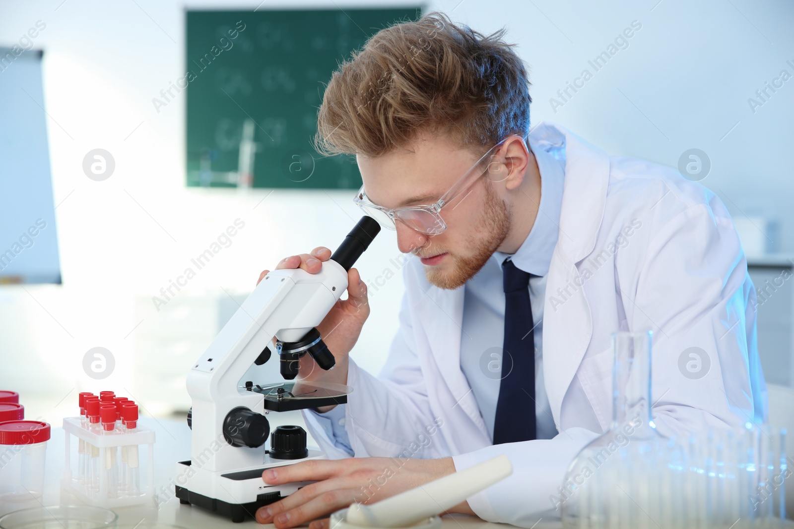 Photo of Male scientist using modern microscope in chemistry laboratory