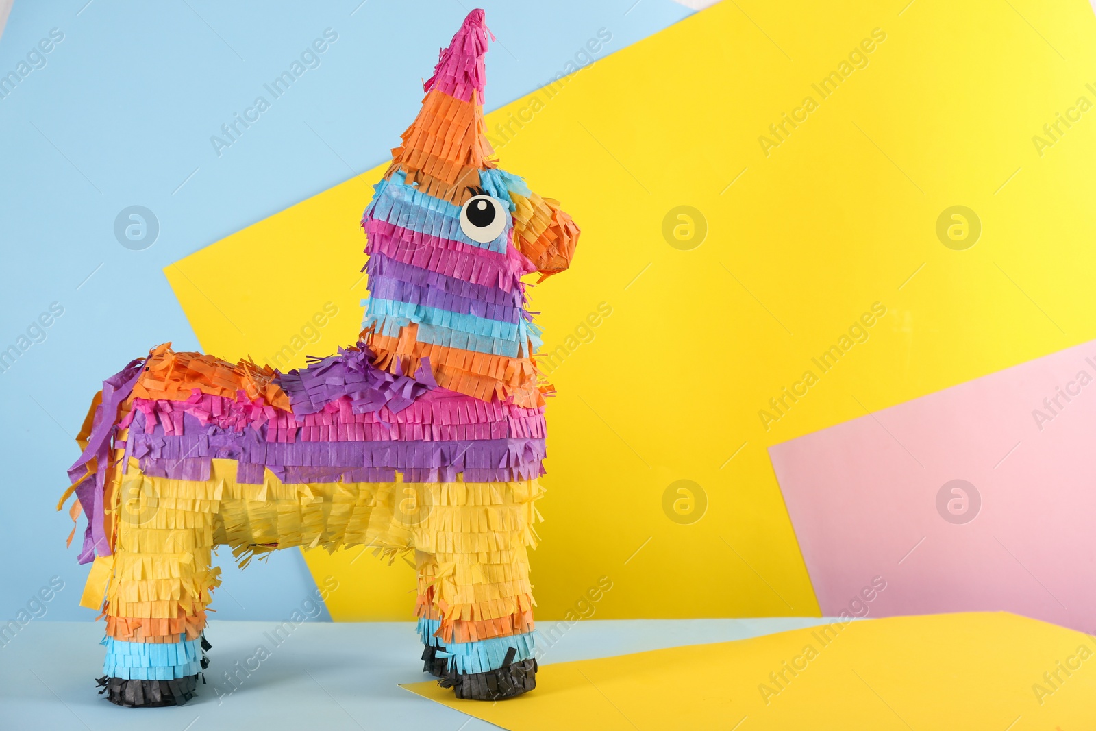 Photo of llama shaped pinata on color background. Space for text